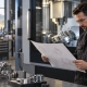 Engineer reviewing a CAD drawing beside a CNC machining center