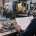 Estimator reviewing an engineering drawing and machined component at a machine shop; conceptual image