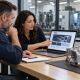 Manufacturing professionals planning a website beside a machined aluminum housing